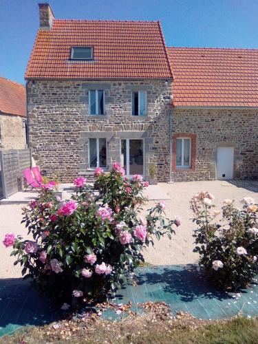 a stone house with flowers in front of it at La Ferme d' Emerentine in Bacilly