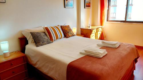 a bedroom with a bed with two towels on it at Enjoy Lisbon Cascais Sintra 1200 metres to metro blue line Sintra Rail line Free Parking in Amadora