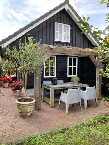 a house with a picnic table in front of it at Uniek houten huis nabij bos en plassen in Hollandsche Rading