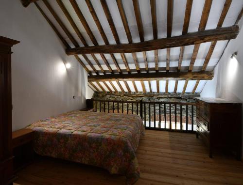 1 dormitorio con cama y techo de madera en Rustico nel Parco Nazionale, en Ronco Canavese