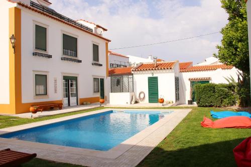 une villa avec une piscine en face d'une maison dans l'établissement Villa Reis - Boutique House, à Golegã
