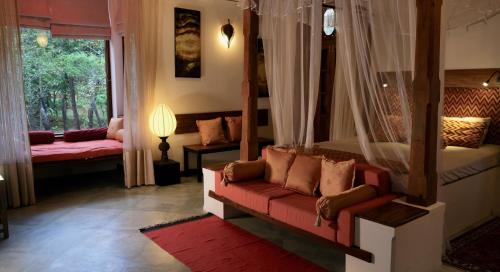 a living room with a red couch and a window at Mind Body and Soul in Dambulla