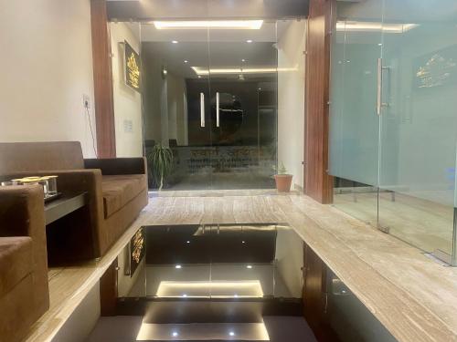 a living room with a couch and a glass floor at Hotel Vrindavan Palace in Indore