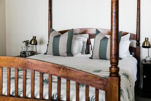 a bedroom with a wooden bed with pillows at Royal Boutique Hotel in Cape Town