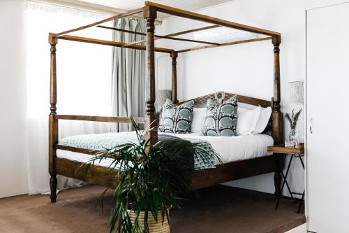 a bedroom with a canopy bed with a potted plant at Royal Boutique Hotel in Cape Town