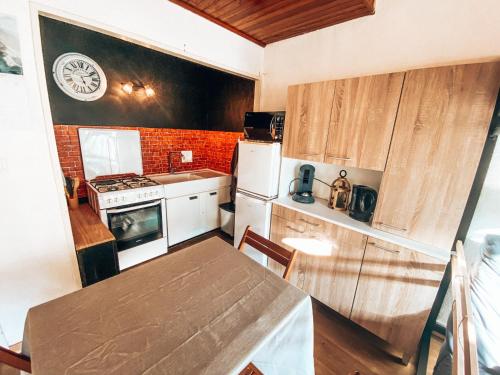 a small kitchen with a table and a stove and refrigerator at Grand Studio « Ô Soleil » 4 pers. 200m des pistes. in La Salle Les Alpes