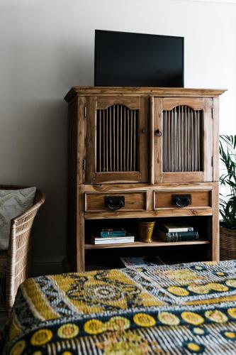 a wooden entertainment center with a flat screen tv on it at Royal Boutique Hotel in Cape Town