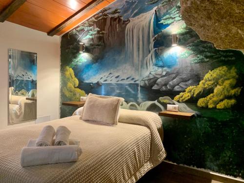- une chambre avec une fresque murale représentant une cascade dans l'établissement Apartamentos3Cuevas, à Setenil de las Bodegas