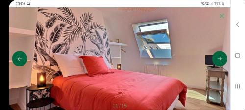 - une chambre avec un lit rouge orné d'une fresque murale de palmiers dans l'établissement La maison du village, à Ploemel