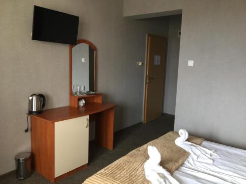 a hotel room with a bed and a desk and a mirror at Sea Horse in Burgas City