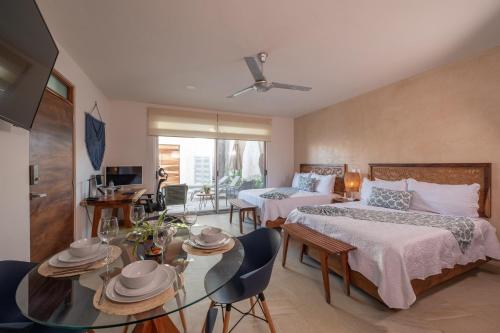 a hotel room with two beds and a table with chairs at Casa del Arbol in Tulum