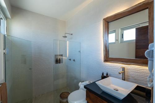 a bathroom with a sink and a glass shower at Casa del Arbol in Tulum