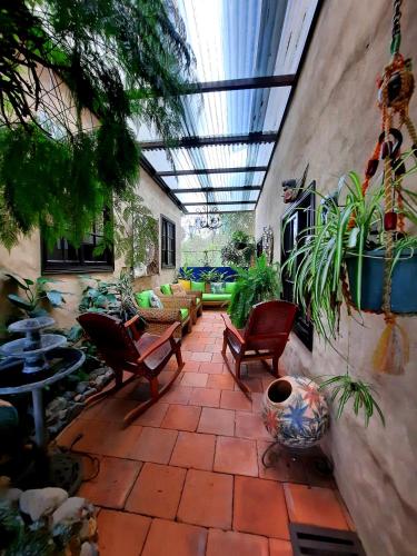 a patio with chairs and plants and a glass ceiling at Cabañas San Miguel in Alto Boquete