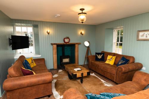 a living room with two couches and a tv at Netherdale House & The Coach House in Turriff