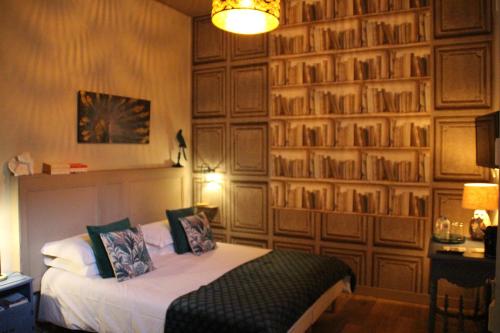 a bedroom with a bed and a wall of books at Une Chambre en Ville in Saintes