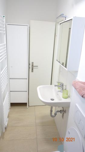a white bathroom with a sink and a mirror at Apartment Weberstrasse in Tübingen