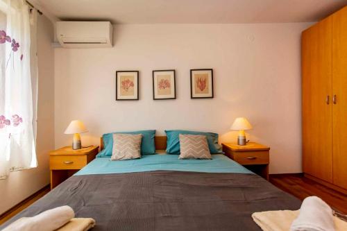 a bedroom with a large blue bed with two lamps at Apartment in Rovinj/Istrien 11481 in Štanga