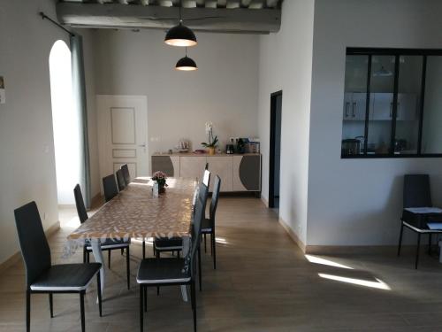 a dining room with a table and chairs at Chambre d'hôtes Le Domaine des Hirondelles in Champcenest