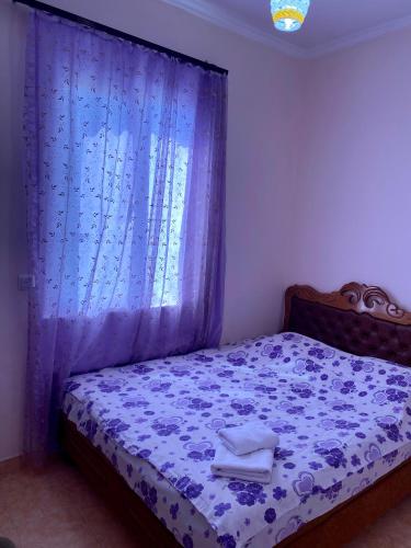 a bedroom with a bed with a blue curtain at Noravank B&B in Chʼiva