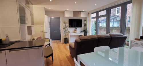 a kitchen and a living room with a couch at Modern City Centre House with Free Parking in Canterbury