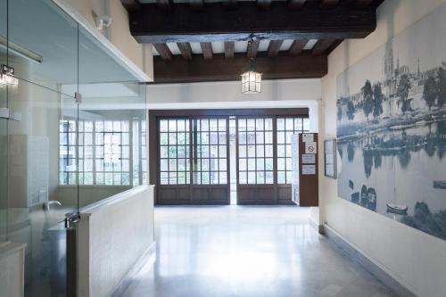 un grand couloir avec des portes et des fenêtres en verre dans un bâtiment dans l'établissement PRESTIGELOC Studio Cosy Place du Martroi Orléans, à Orléans