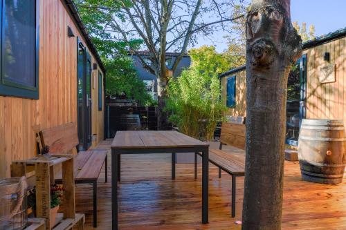 a wooden deck with a table and a tree at Racoon - Außergewöhnliches Tinyhauserlebnis beim Reptilienzoo Reptilium in Landau in der Pfalz