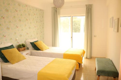 um quarto de hotel com duas camas e uma janela em Casa do Mar - Apartamento com vista Ria e Mar na Fuzeta