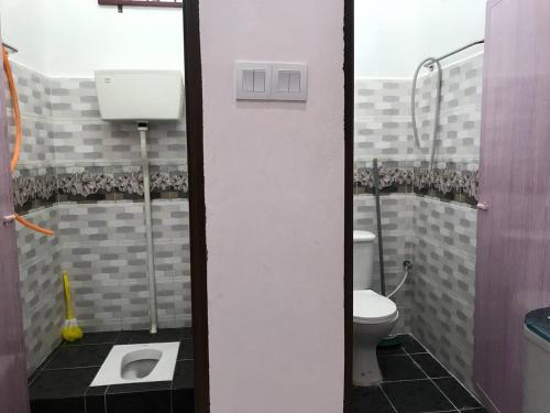 een badkamer met een toilet en een wastafel bij Tok Chik Homestay in Kampong Lubok Bedil