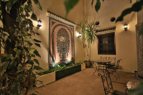 a room with a table and chairs and a picture on the wall at Riad Jardin Chrifa in Fès