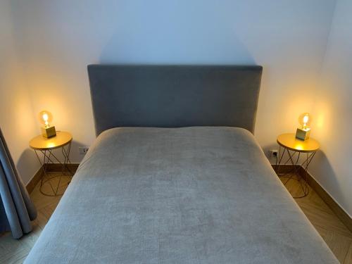 Bett mit zwei Leuchten an den Seiten in der Unterkunft Le Sancy appartement in Beausoleil