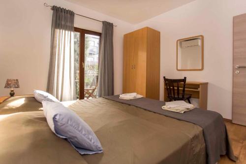 a bedroom with a bed with a desk and a window at One-Bedroom Apartment in Rovinj VII in Štanga