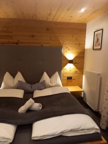 ein Schlafzimmer mit einem großen Bett mit weißen Kissen in der Unterkunft Haus Höllwart in St. Johann im Pongau