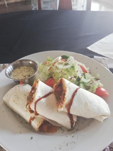 a plate of food with a wrap and a salad at Farmhouse Boutique Backyard Rooms in Outjo