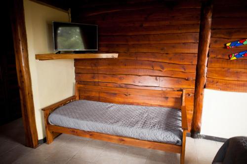 Un dormitorio con una cama con un televisor en la pared. en Cabaña Bariloche, en San Carlos de Bariloche