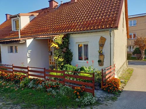 een klein wit huis met een rood dak bij Mieszkanie w domu wielorodzinnym in Ryn
