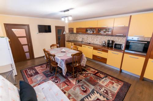 a kitchen with a table and a kitchen with yellow cabinets at Apartament Mario in Râşnov