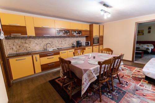 a kitchen with a table and a kitchen with yellow cabinets at Mario's Cozy Apartment in Râşnov