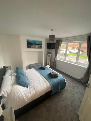 a bedroom with a bed and a large window at Lovely 1-bedroom apartment with garden and parking in Stone