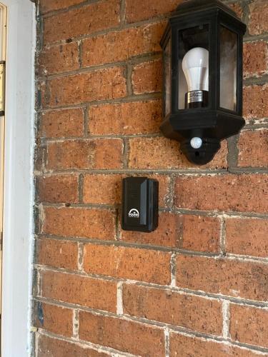 a light on a brick wall at Lovely 1-bedroom apartment with garden and parking in Stone