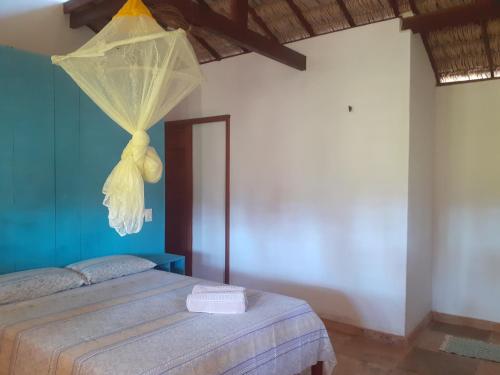 a bedroom with a bed with a net on it at Chalés Bons Ventos - Icaraizinho in Icaraí