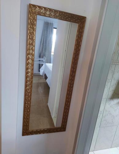 un espejo en una pared junto a un dormitorio en LU'S HOSTING en Treze Tílias