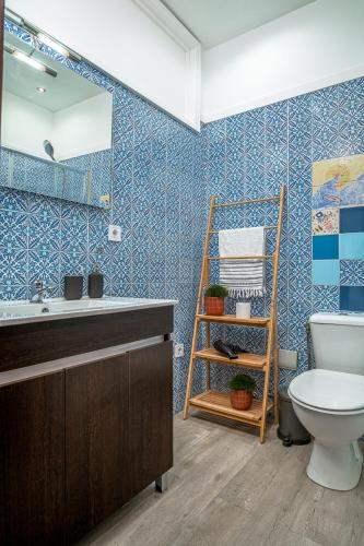 a bathroom with a toilet and a sink and a mirror at Avenue View Rooms in Porto