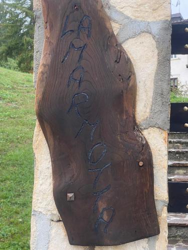 a wooden sign on a wall with writing on it at Artemide Domus in Pescocostanzo