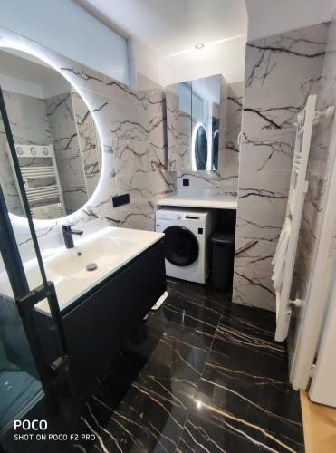 une salle de bain avec un lavabo et une machine à laver dans l'établissement Holiday Vigie Promenade, à Nice