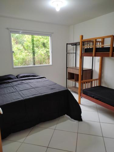 - une chambre avec un lit, des lits superposés et une fenêtre dans l'établissement Temporada balneário camboriu, à Balneário Camboriú