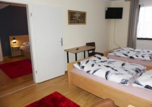 a bedroom with two beds and a television in it at Hotel Akropolis in Herford