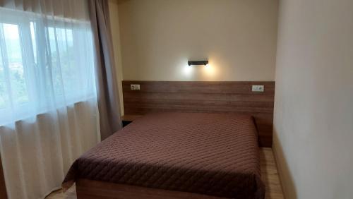 a small bed in a room with a window at Forest Apartment in Sapareva Banya