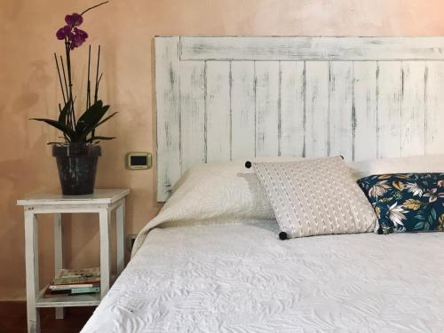 a bed with a wooden headboard and a pillow on it at Agriturismo Salcino in Grosseto