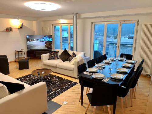 a living room with a table with chairs and a couch at Ferienwohnung Rütiboda 8-10 Personen in Davos