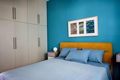 - une chambre avec un mur bleu et un lit dans l'établissement Mirtos Luxury apartment, à Myrtos